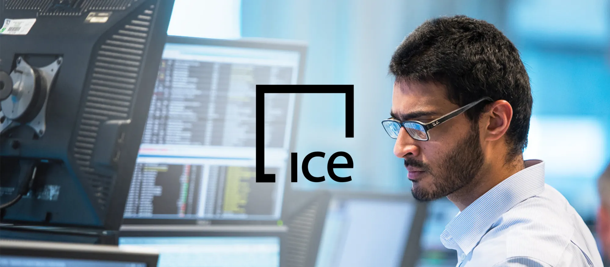 ICE with a man looking at a computer in the background.