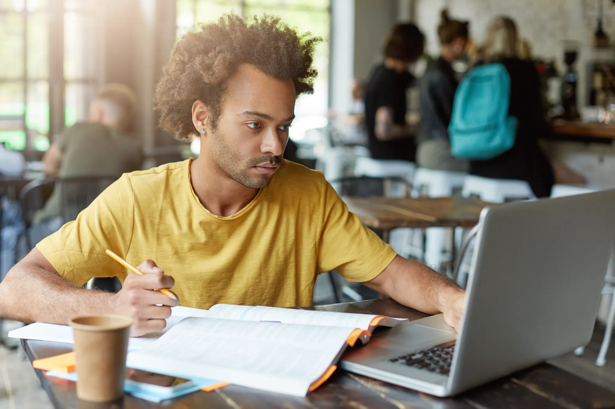 Man sitting at desk using laptop to study in a university setting