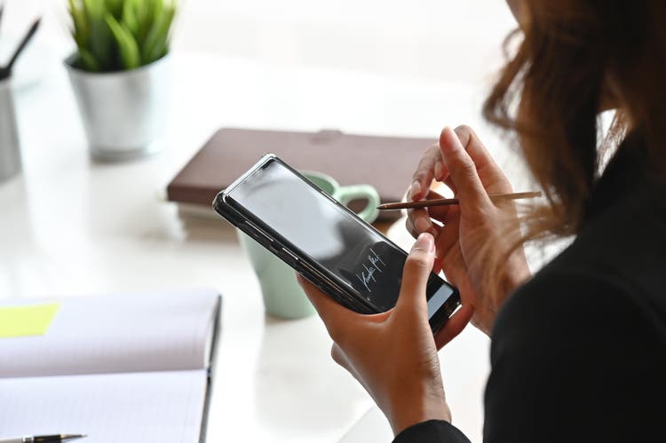 Woman holding a mobile device.