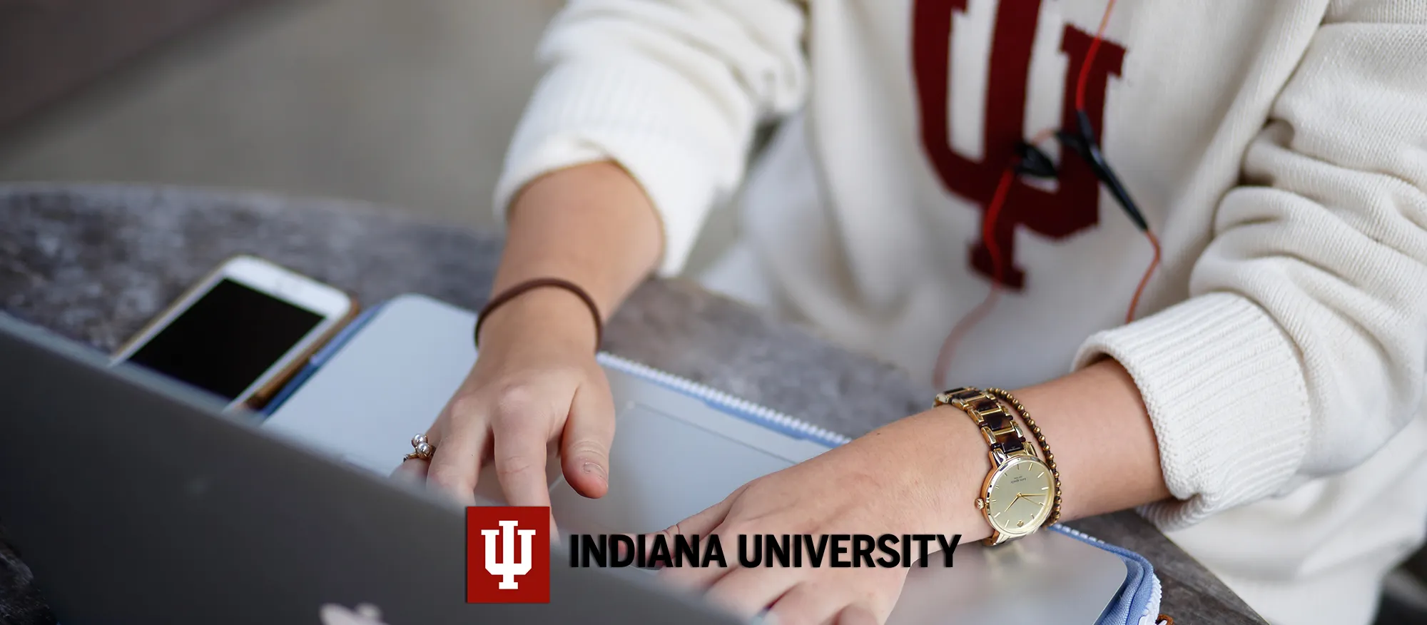 Indiana University, person working on a laptop.