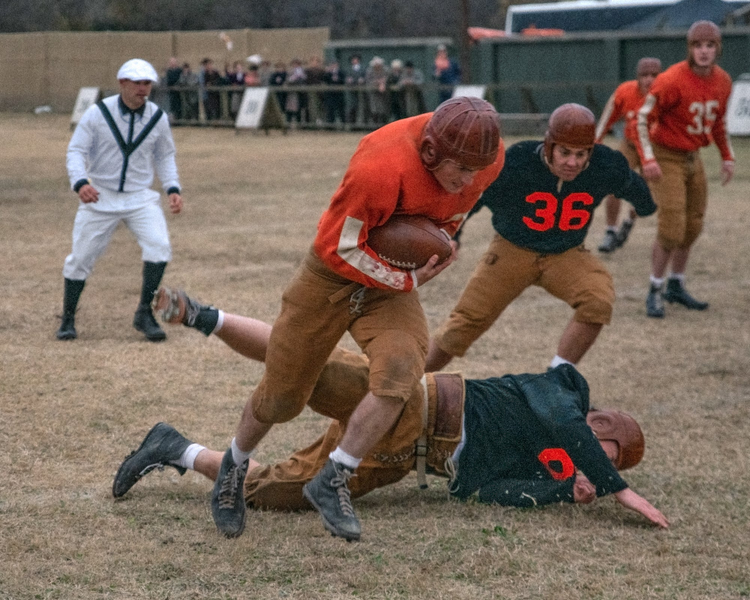 Football player runing and carrying a football.