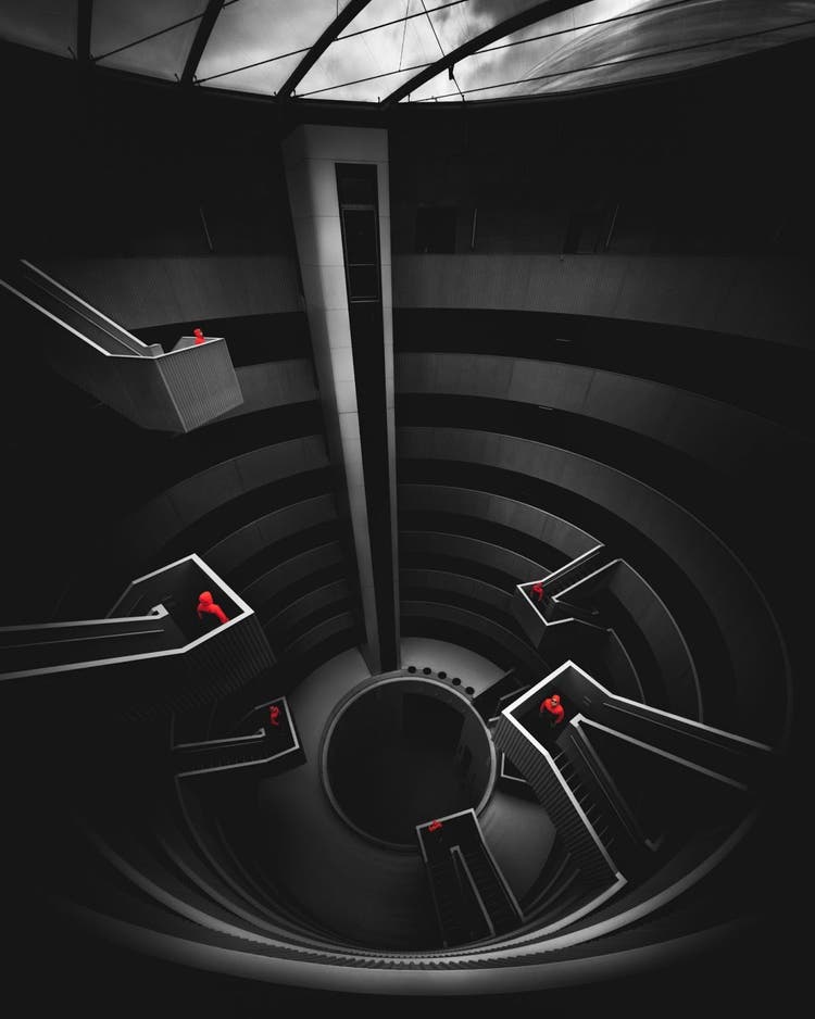 A composite photograph of staircases inside a building makes use of blue hour.