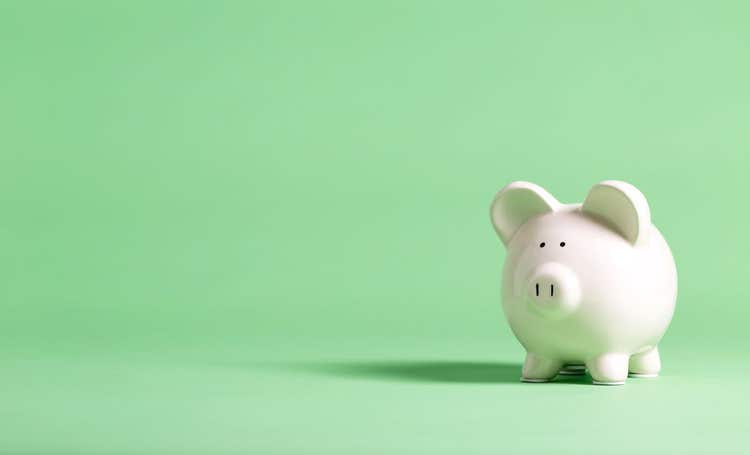 White piggy bank against a green background.