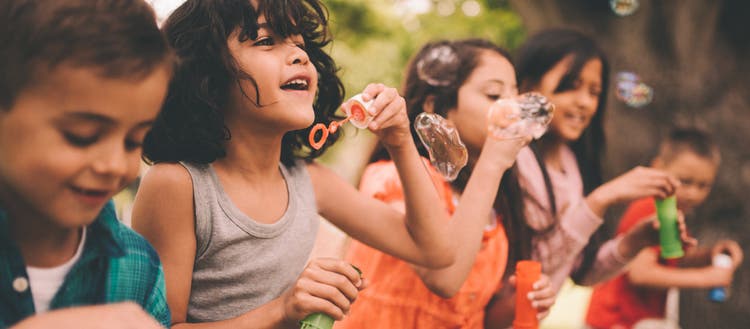 Five children blowing bubbles.