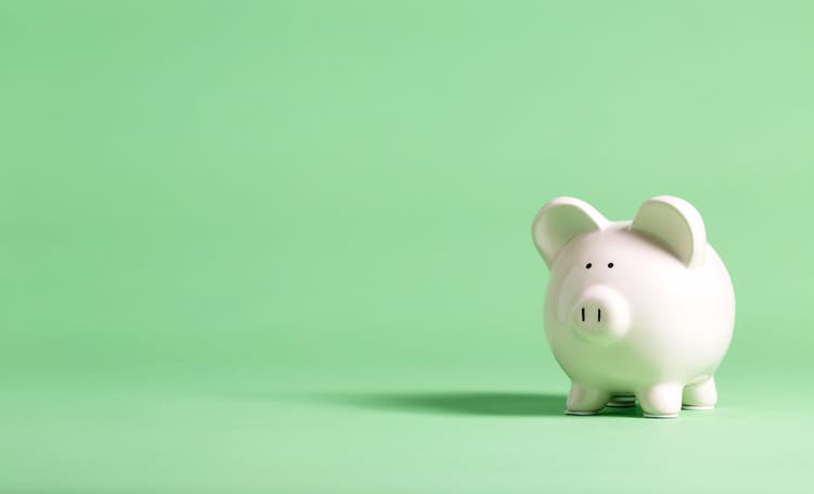 White piggy bank against a green background.