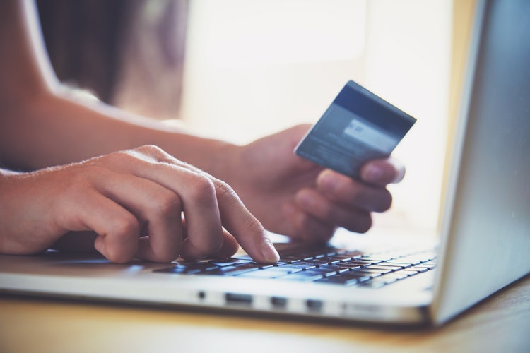 Image of person online shopping on a laptop with credit card.