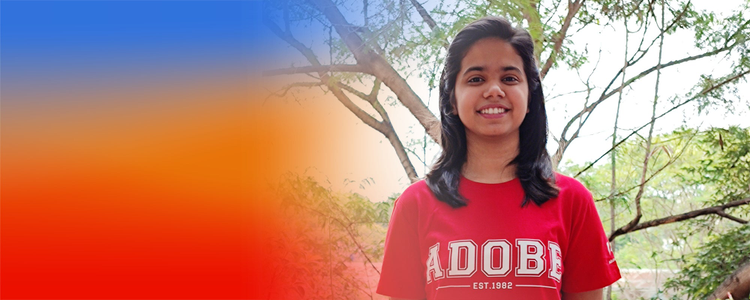 An Adobe India Intern wearing her Adobe shirt and smiling. 