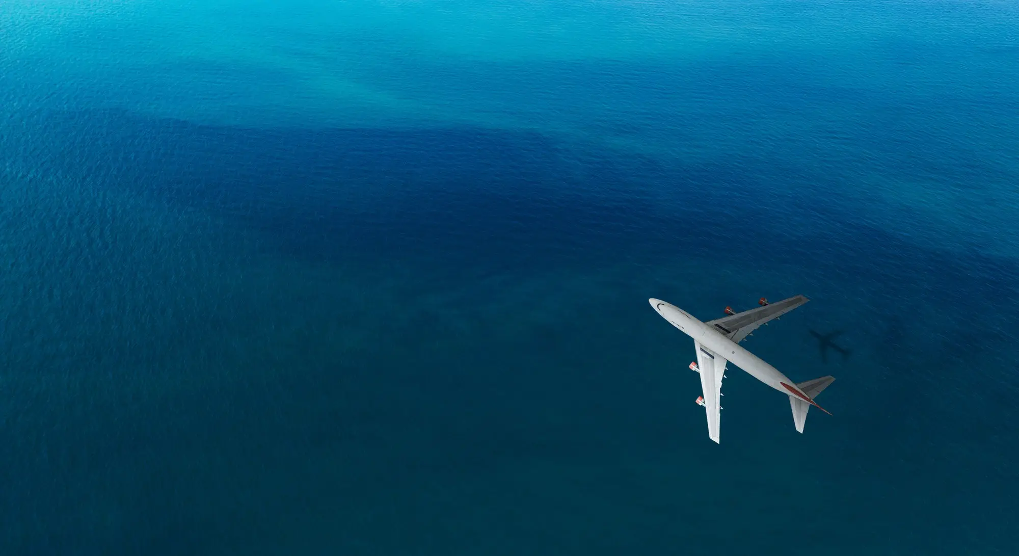 Airplane flying over blue water. 