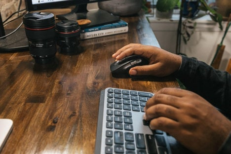 Image of Aundre Larrow using a mouse and keyboard. 