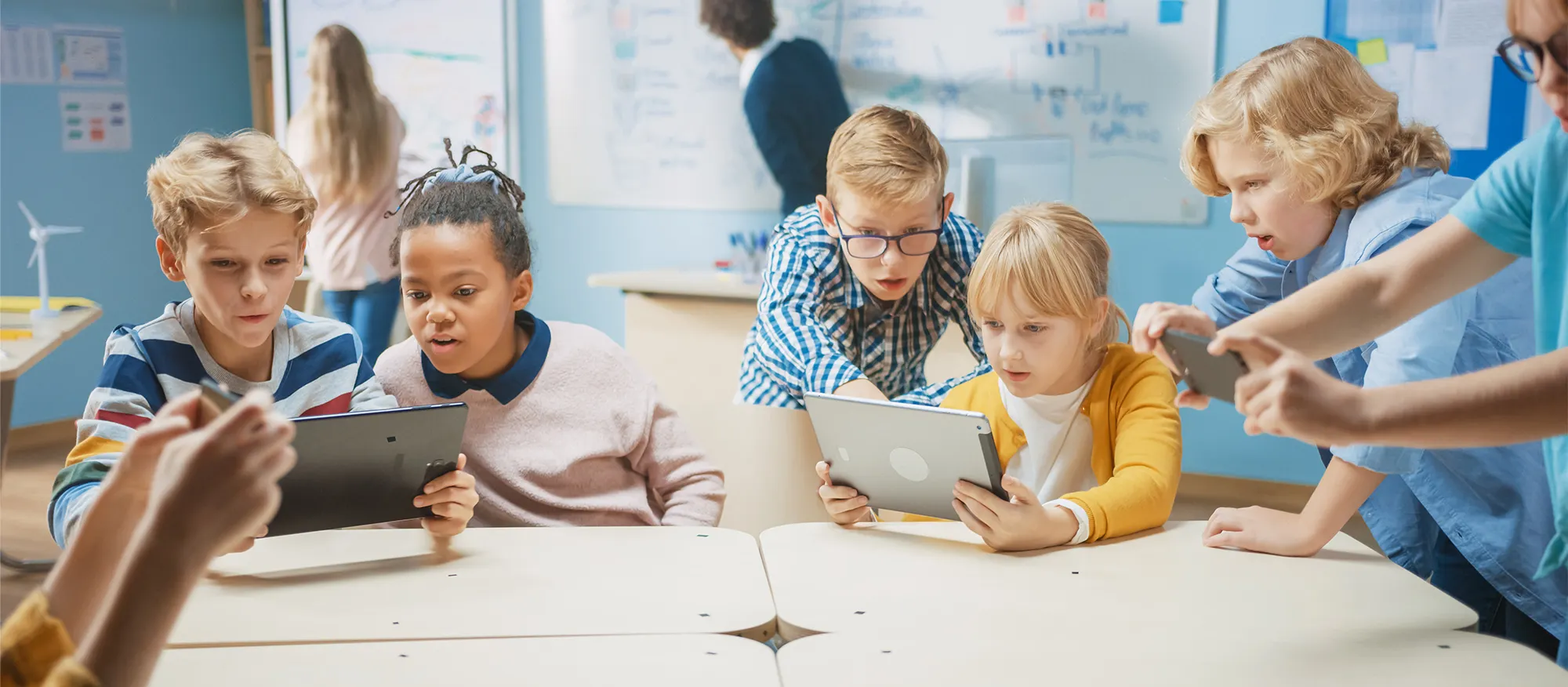 Group of children looking at electronics.