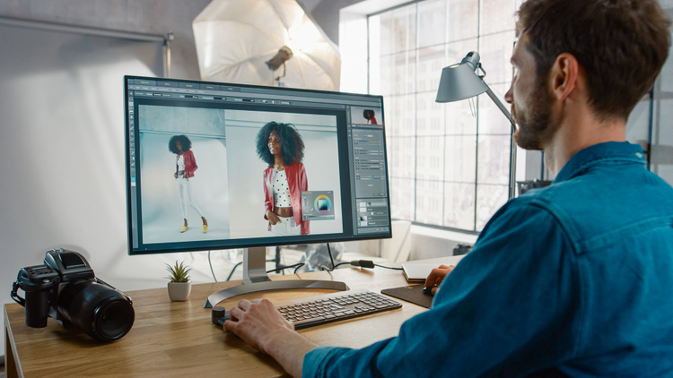 Man editing photos on a computer screen. 