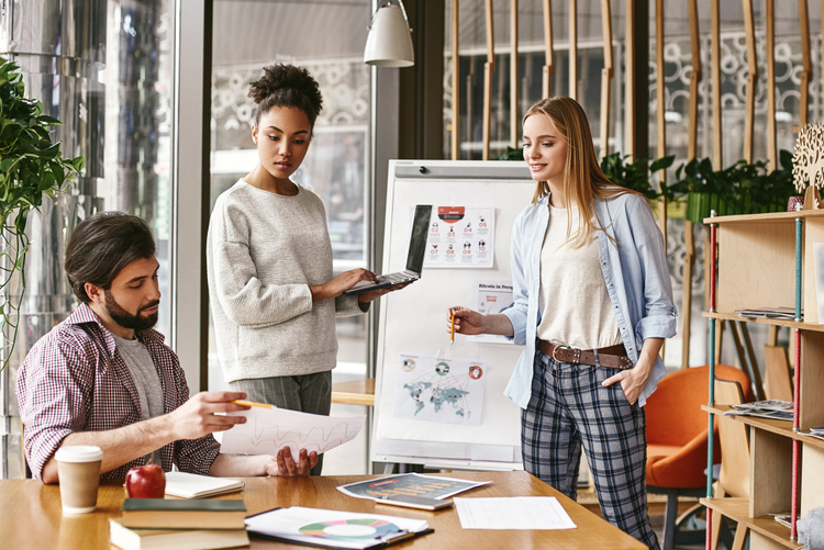 Three co-workers are comparing results and developing a strategy