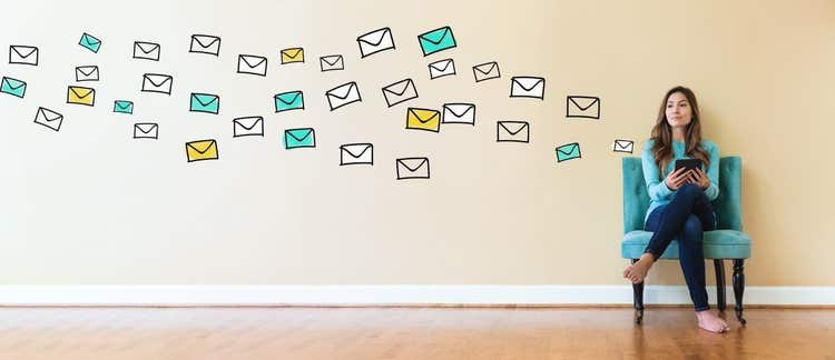 Woman sitting in chair with illustrations of emails coming out
