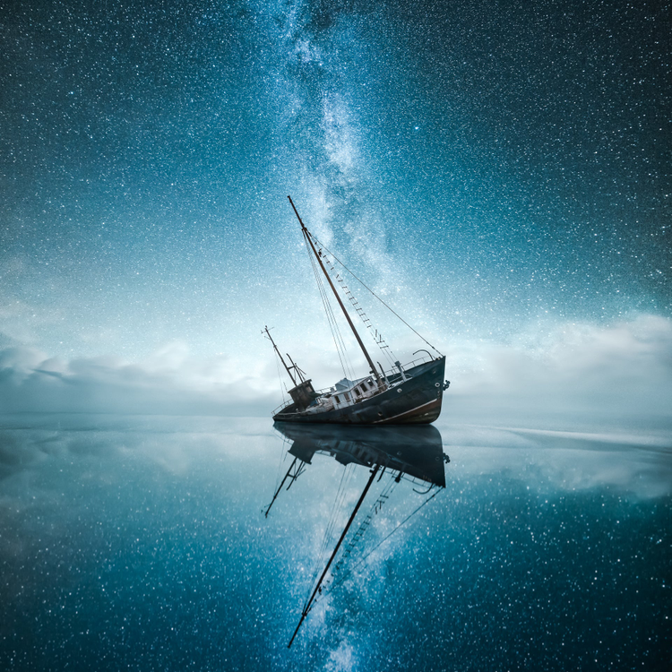 Photograph of a boat tilting in the water surrounded by stars. 