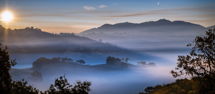 Photo of sunrise over a mountain range. 