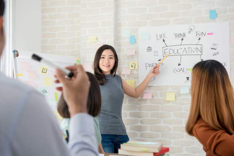Female college student making a presentation in classroom.