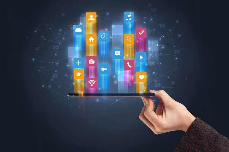 Businessman hand using phone with flying application icons around.