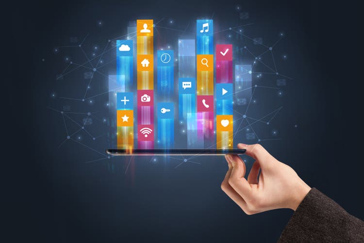 Businessman hand using phone with flying application icons around.