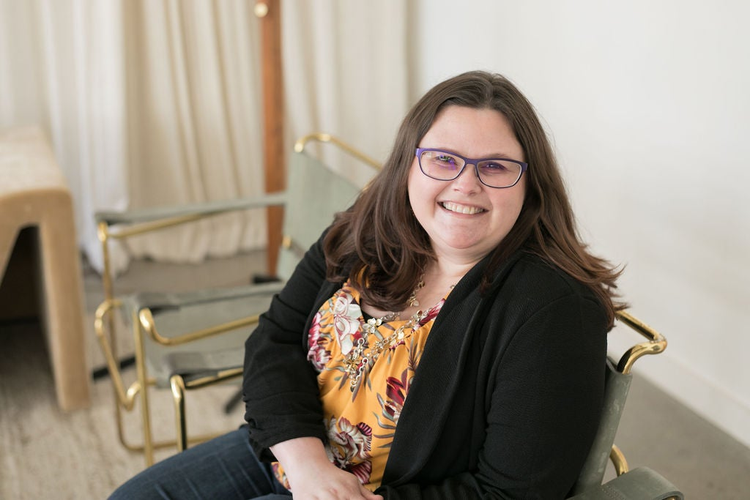 A photo of Jessica Michaels sitting on a chair and smiling.