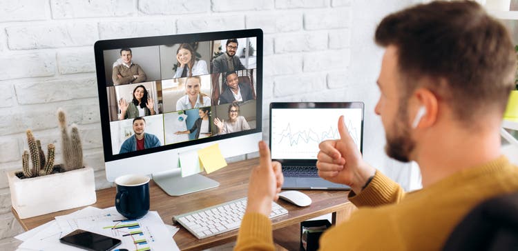 Man in a group meeting on his computer.