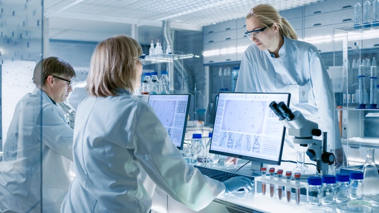 In Modern Laboratory Senior Female Scientist Discusses Work with Young Female Assistant.