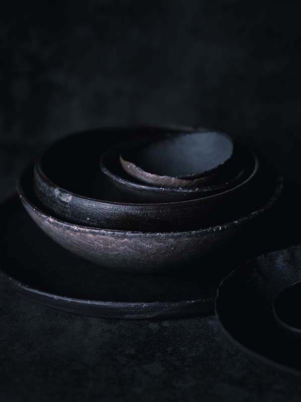 Macro photography of nutmeg seeds placed inside ceramic dishware.