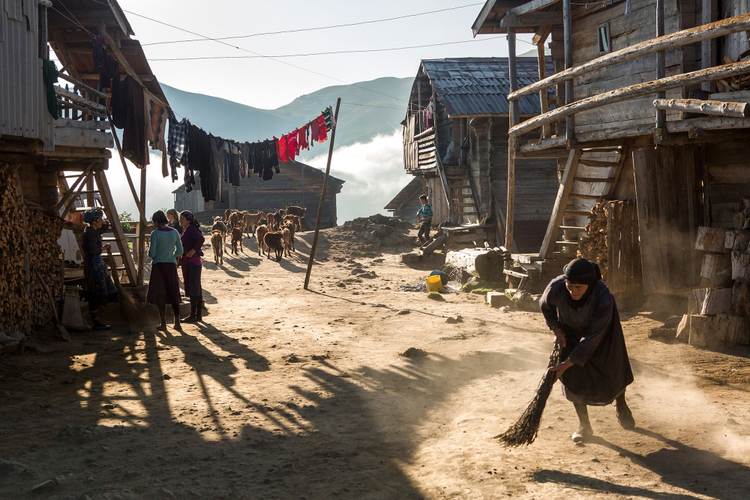 Woman sweeping the dirt. 