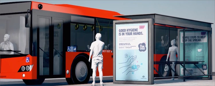 Digital image of person waiting at a bus stop standing in front of an orange bus. 