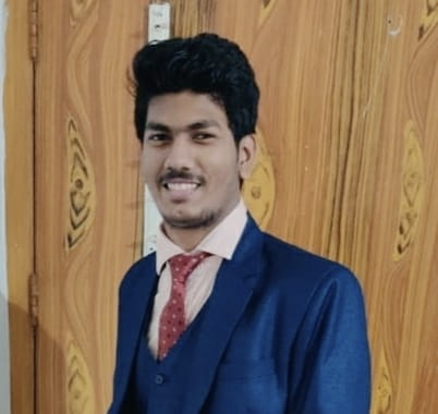 A photo of Ashutosh Kumar. He's wearing a blue suit and a red tie.