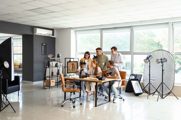 Professional photographer teaching young people in studio.