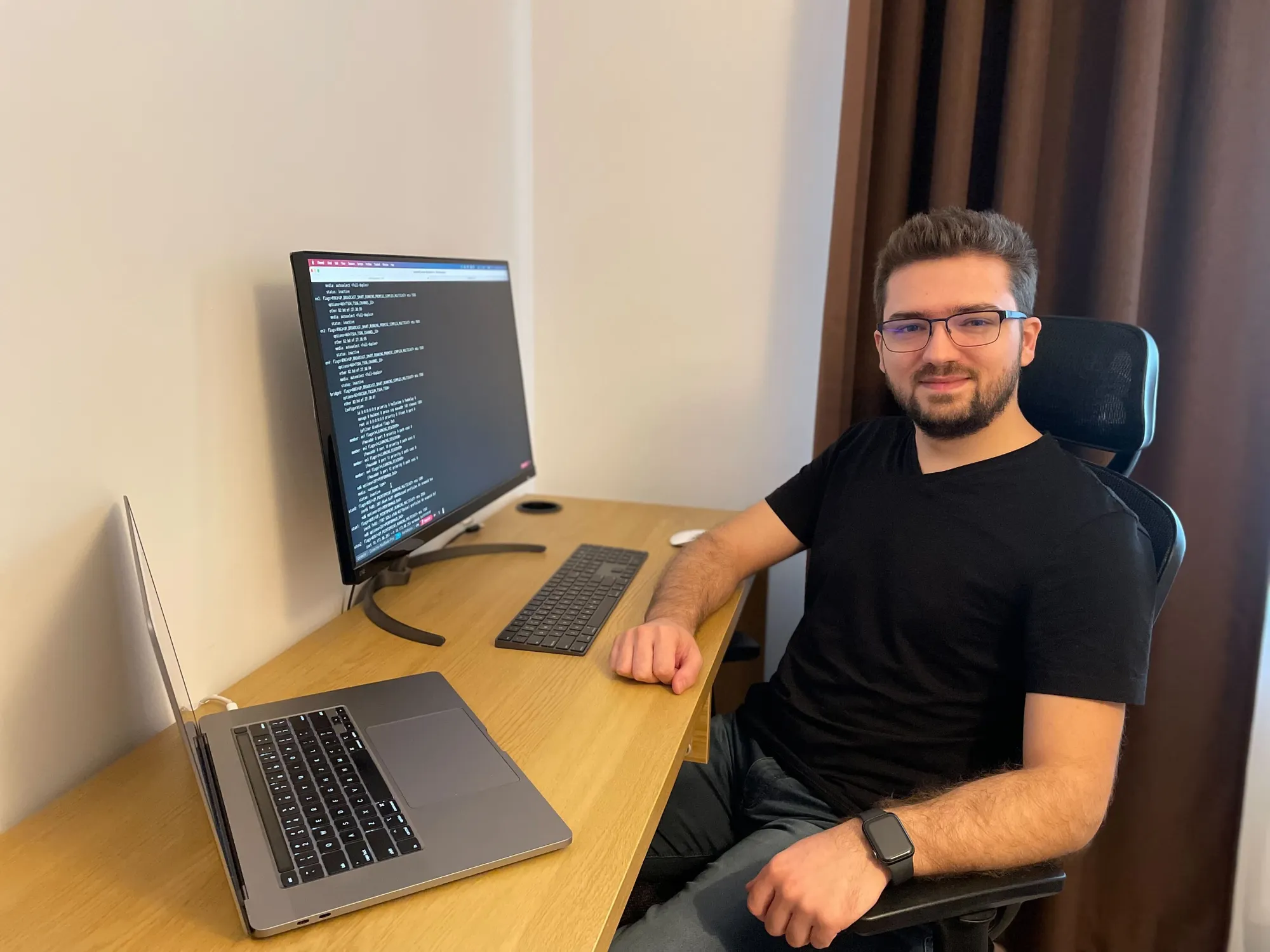 Adobe Software Engineer, Cosmin Ionita, sitting in his home office in front of his laptop and computer monitor.
