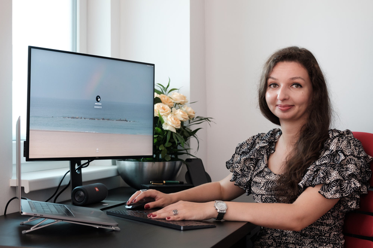 Adelina in her home office in front of her computer.