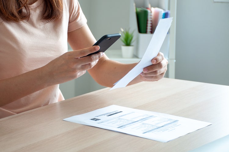 A woman uses a smartphone to scan the barcode.