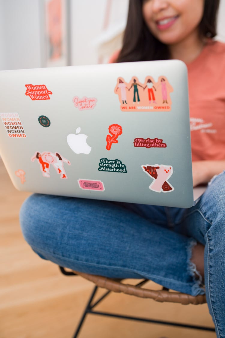 Image of Lisa Nicole Rosado on her laptop with stickers.