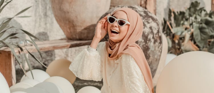 Woman in sunglasses smiling.