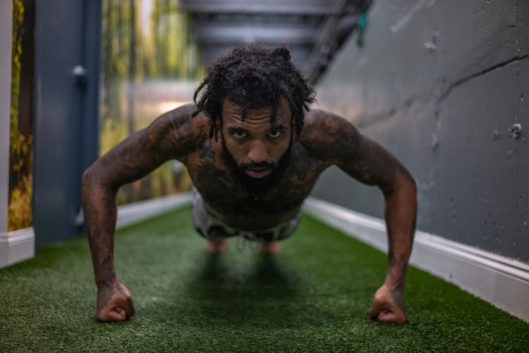 Image of a man doing a push up on his fists.