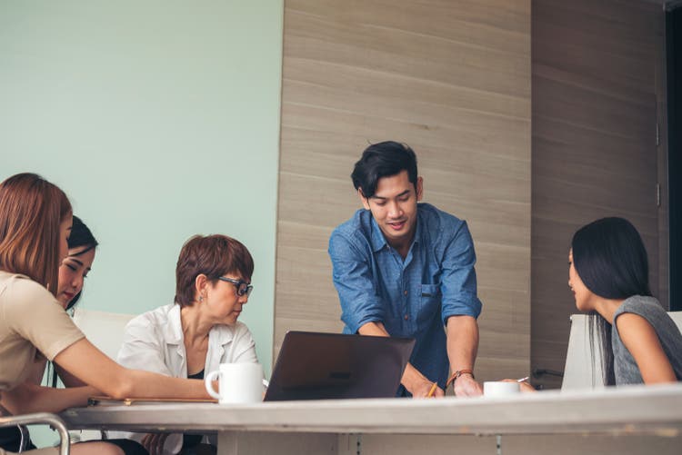 Five people sitting in an office working together