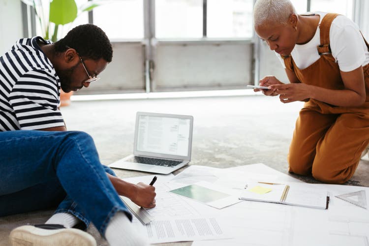 Two people looking over a pile of papers.