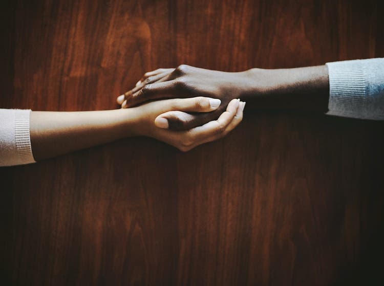 Two hands holding each other