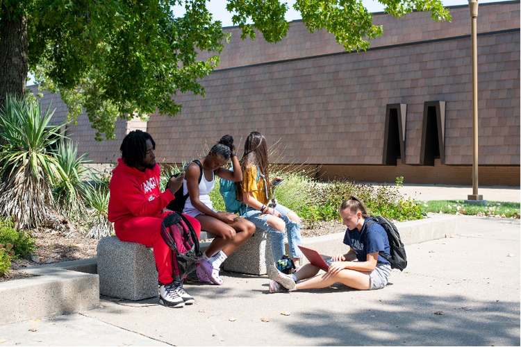 Students sitting on benches on the campus of Butler Commmunity College 