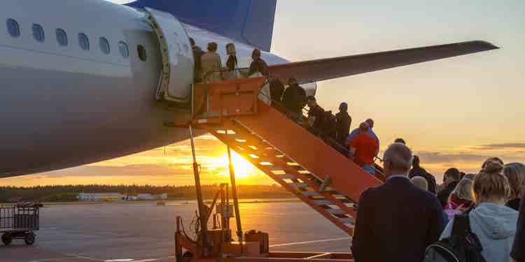 People boarding plane, travelers.