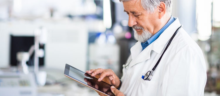 Doctor using an ipad and Acrobat Sign to work.