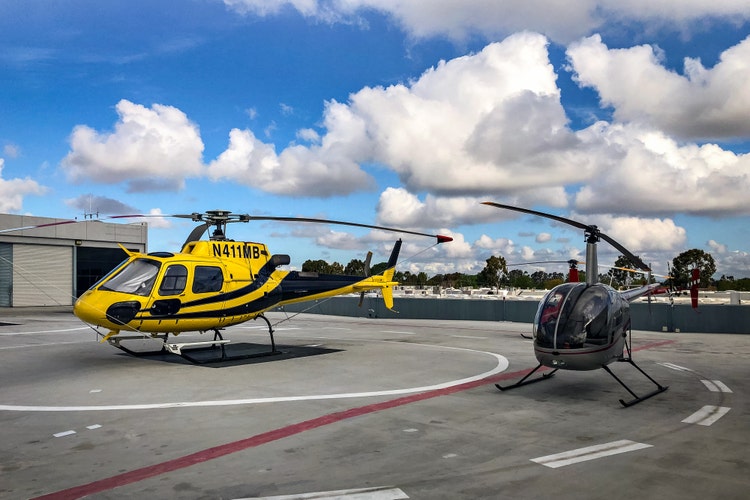 Yellow and black helicopters at a landing pad.