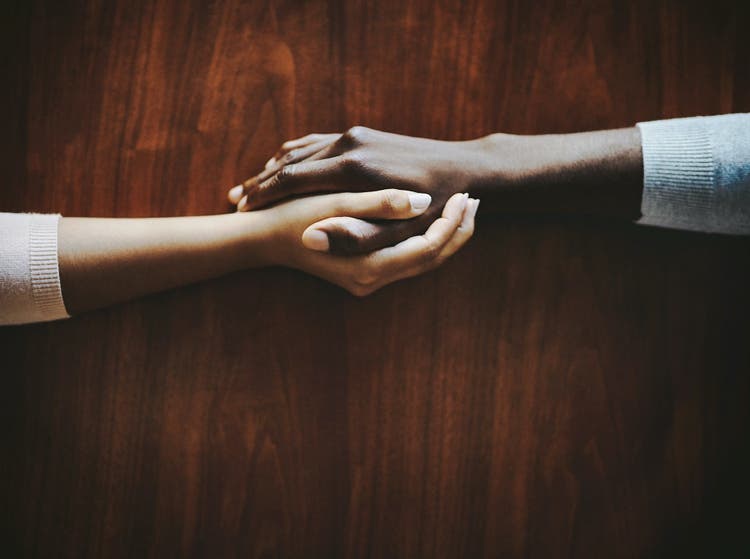 Two hands holding each other