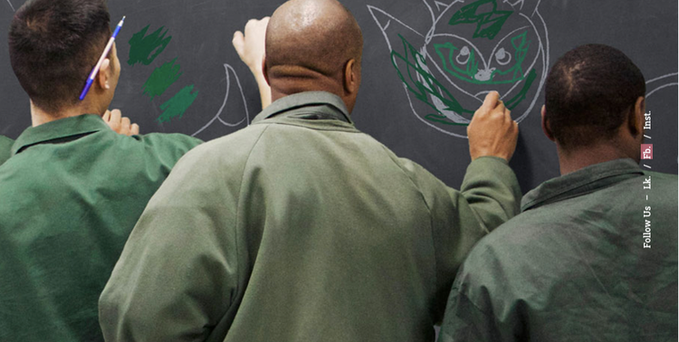 Prison inmates drawing creatively on a chalk board