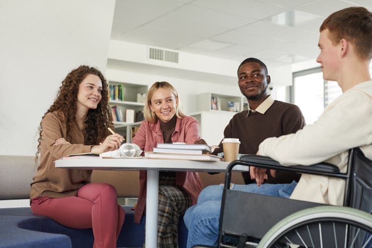 Multi-ethnic group of students studying in college library.