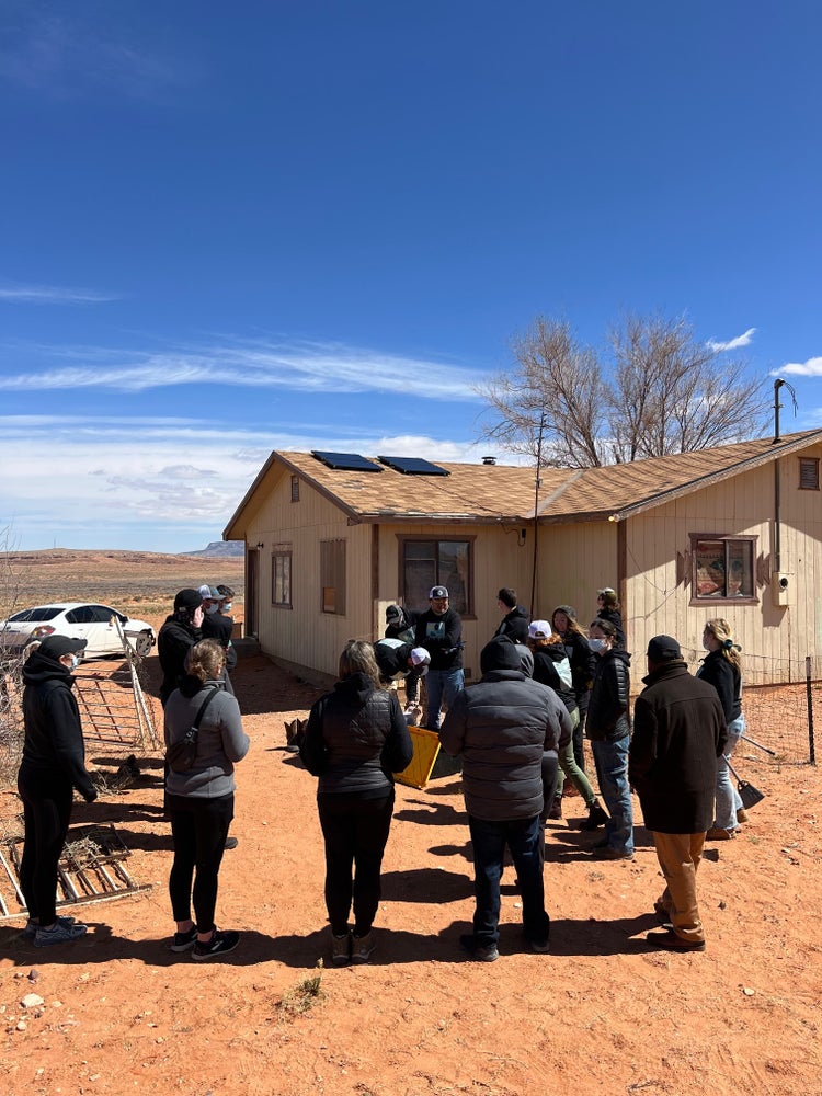 Photograph by Mylo Fowler of a group of people installing solar panels and electricity on the Navajo Reservation