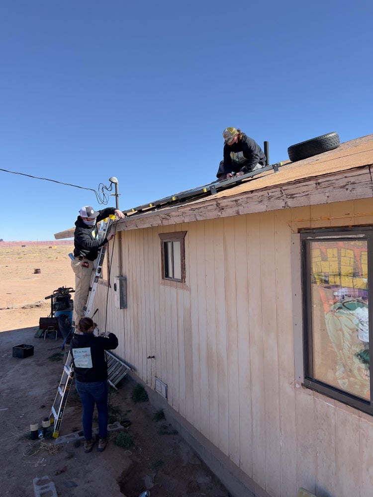 Photograph by Mylo Fowler of a group of people installing solar panels and electricity on the Navajo Reservation