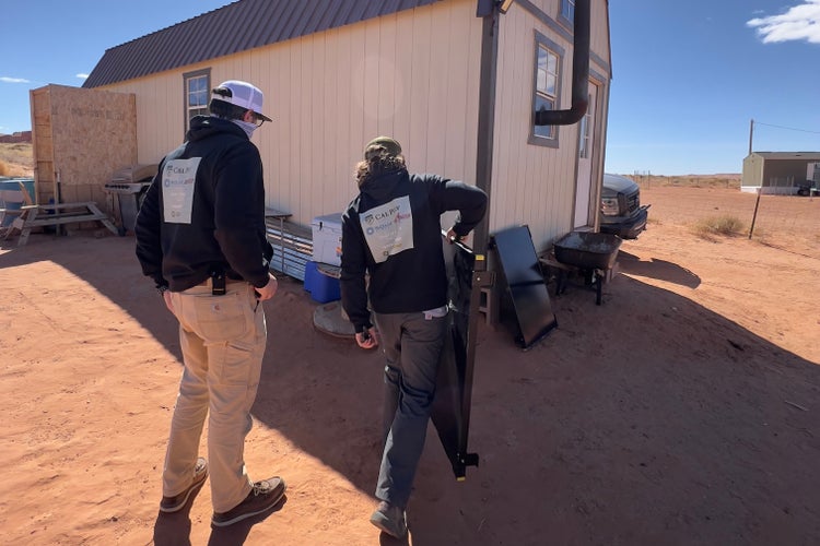 Photograph by Mylo Fowler of a group of people installing solar panels and electricity on the Navajo Reservation