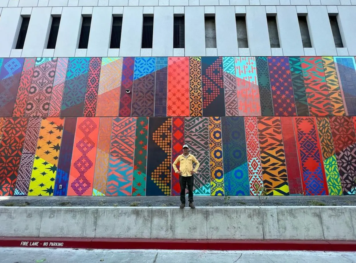 Leo Bersamina in front of the mural he and his team designed and created.